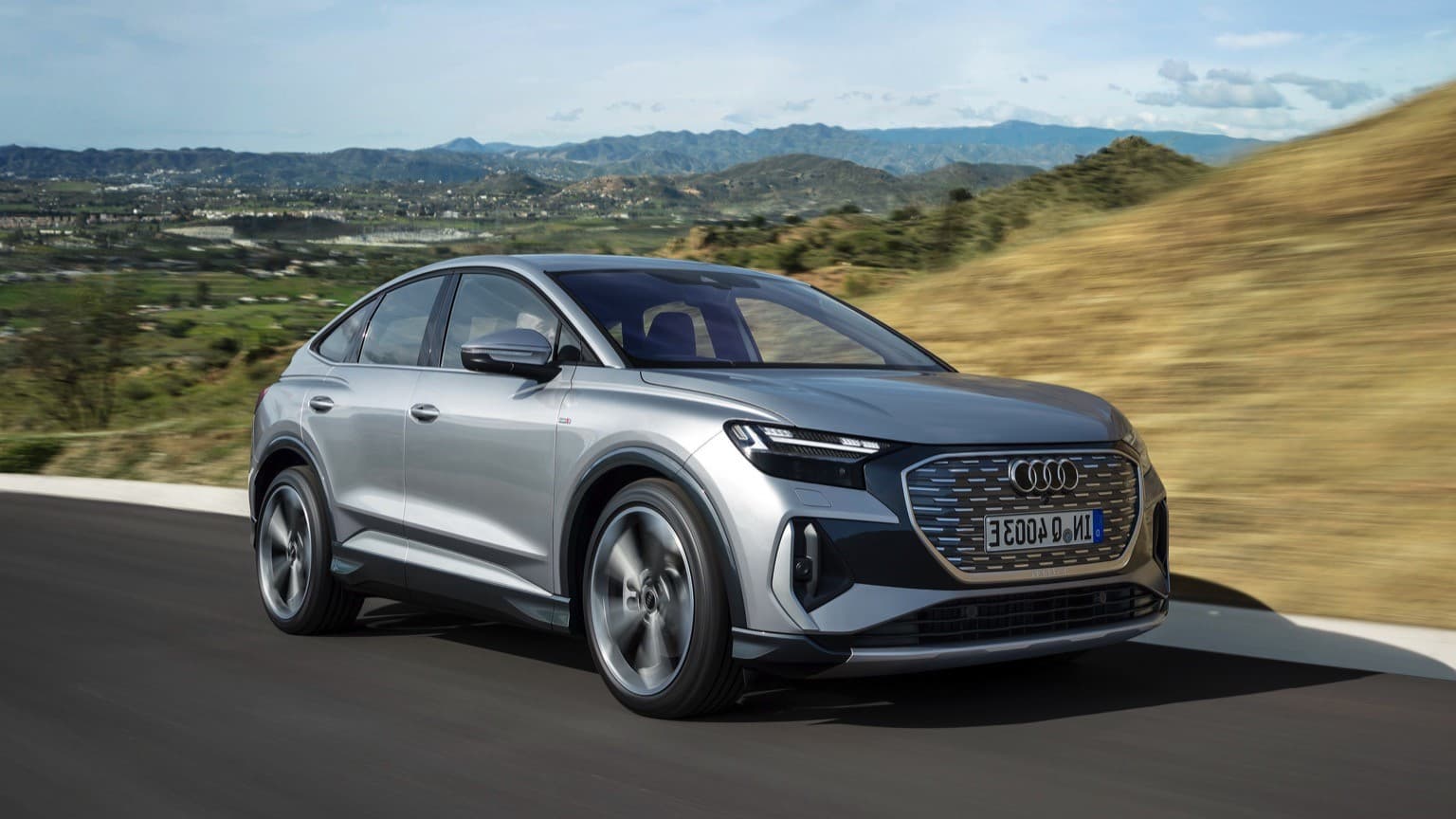 a silver car driving on a road