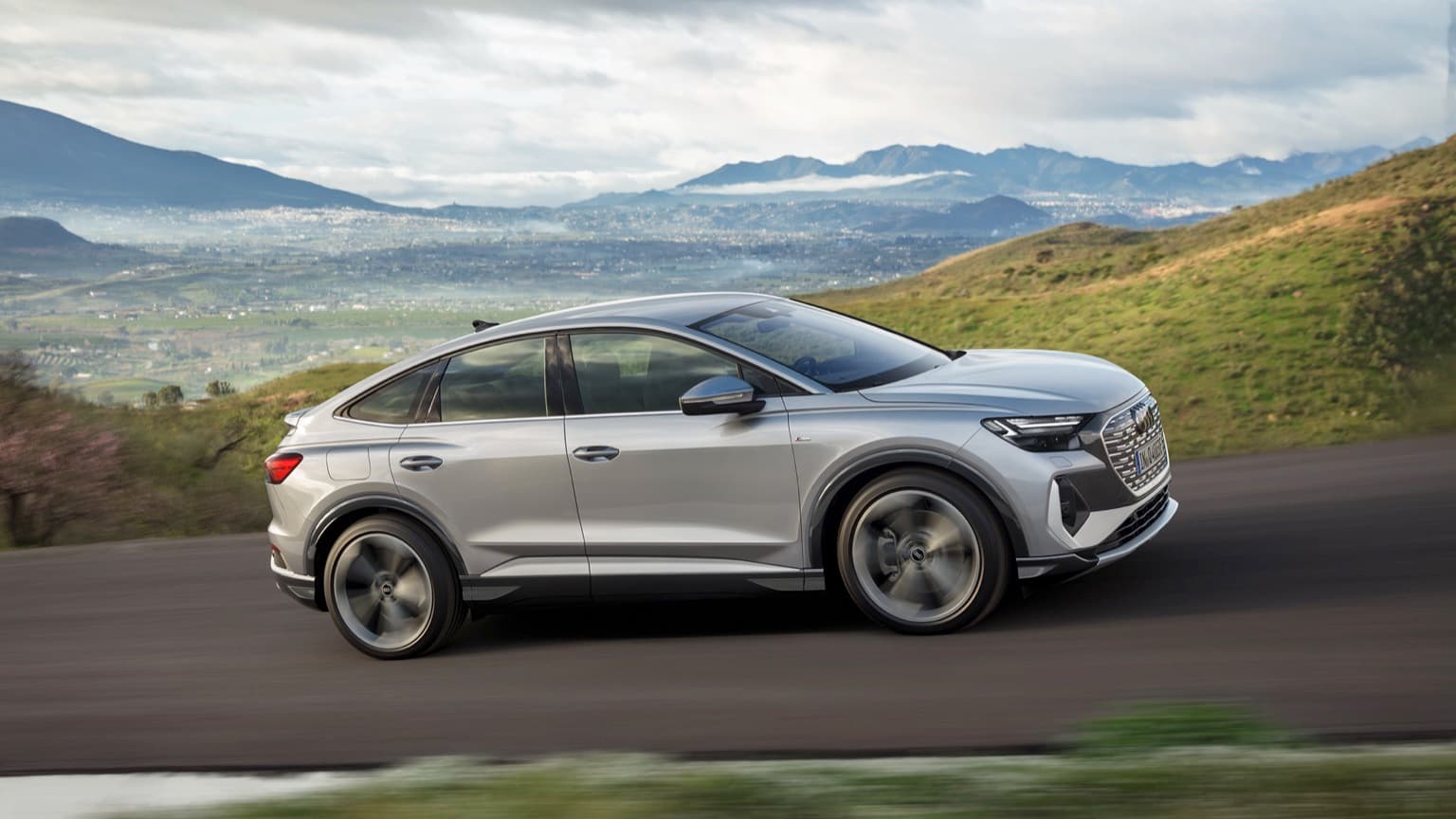 a silver car driving on a road