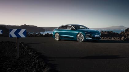 une voiture bleue garée sur une route près d'un plan d'eau