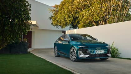 une voiture bleue garée devant une maison blanche