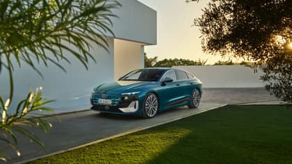 une voiture bleue garée devant un bâtiment blanc