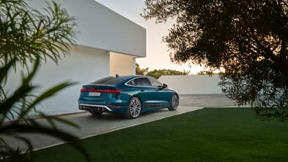 une voiture bleue garée devant un bâtiment blanc