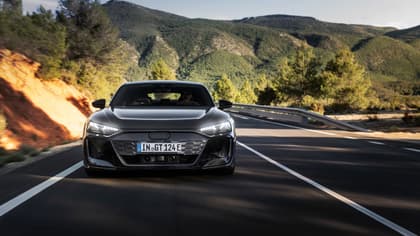voiture noire roulant sur une route avec des montagnes en arrière-plan
