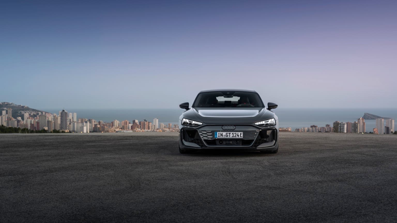 a car parked on a road with a city in the background