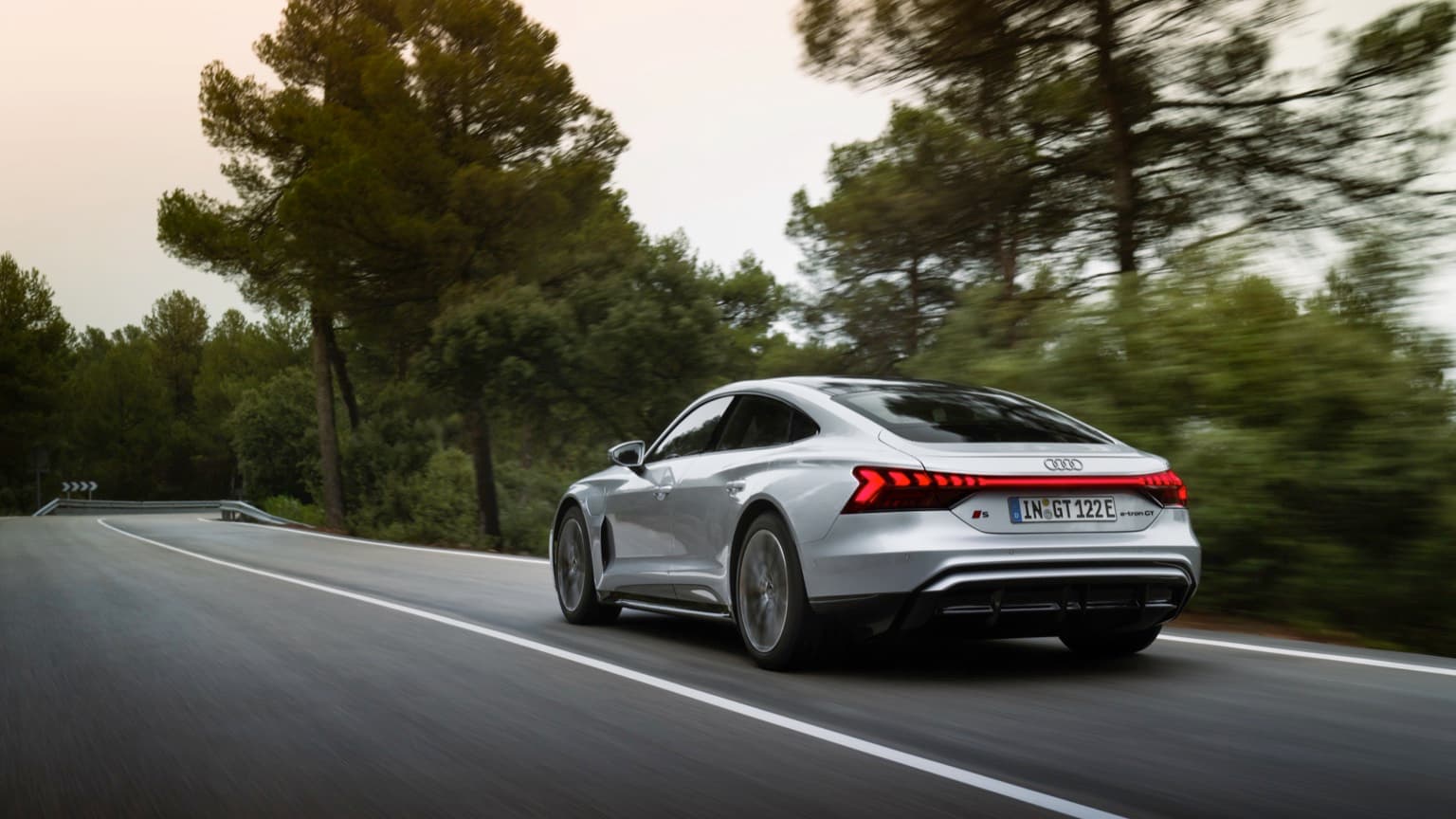 a silver car driving on a road
