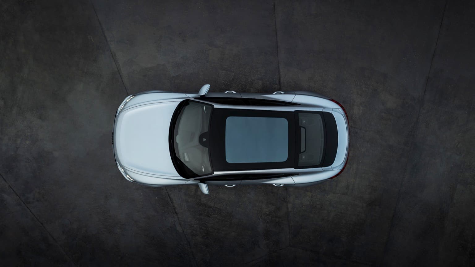 a silver car parked on a black surface