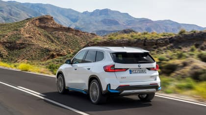 voiture blanche roulant sur une route avec des montagnes en arrière-plan
