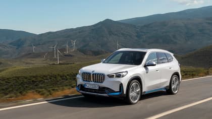 une voiture roulant sur une route avec des éoliennes en arrière-plan