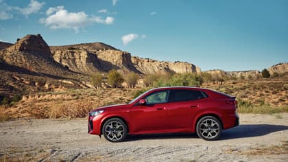 une voiture rouge sur un chemin de terre