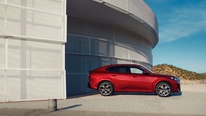 une voiture rouge garée devant un bâtiment
