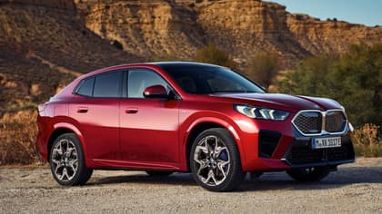une voiture rouge garée sur un chemin de terre