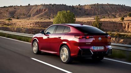 une voiture rouge roulant sur une route