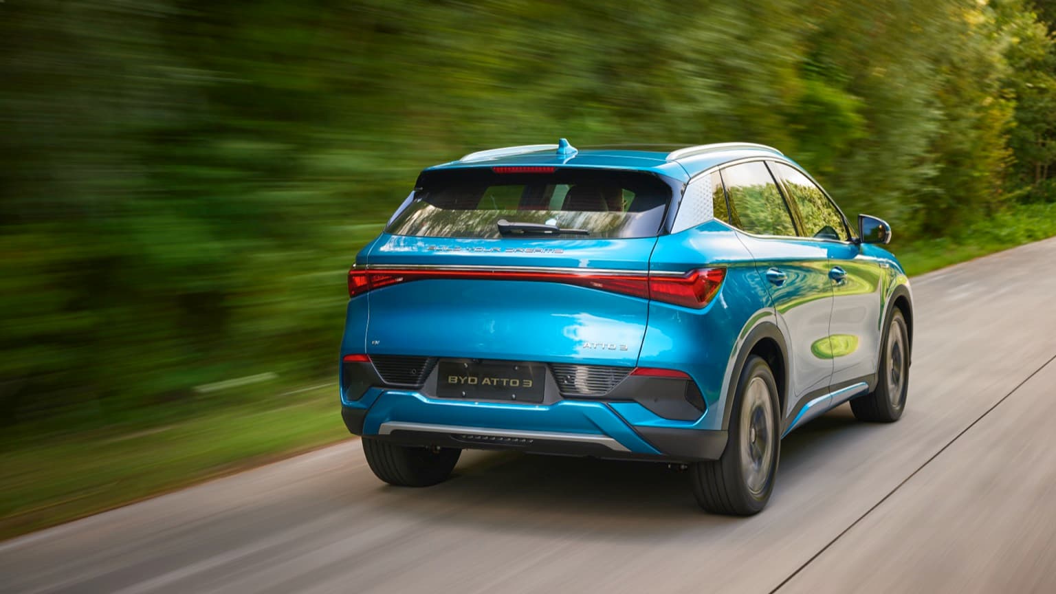 une voiture bleue roulant sur une route