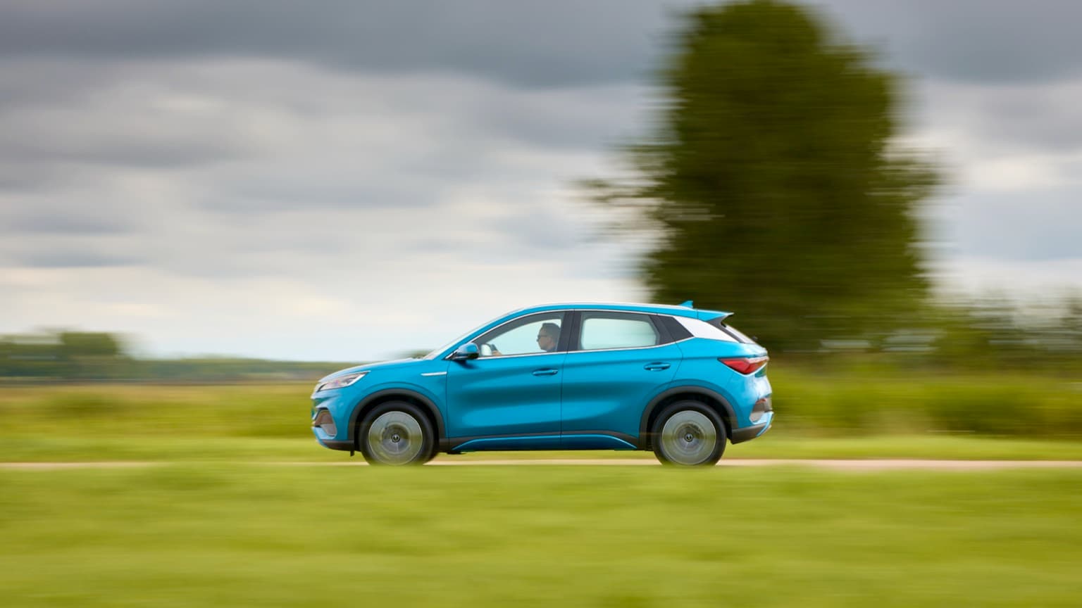 une voiture bleue roulant sur une route