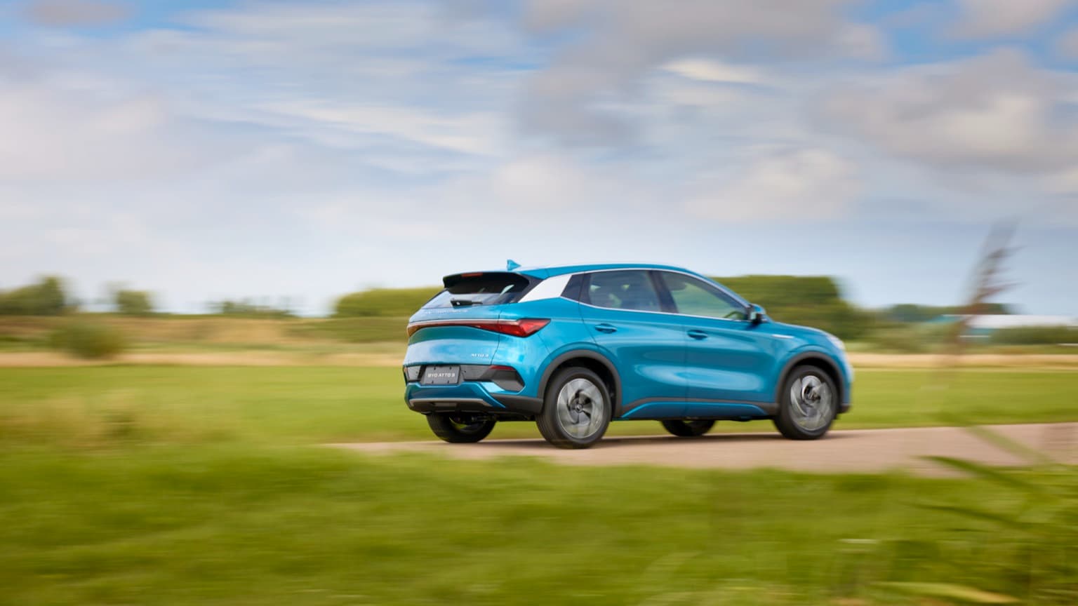 une voiture bleue roulant sur une route
