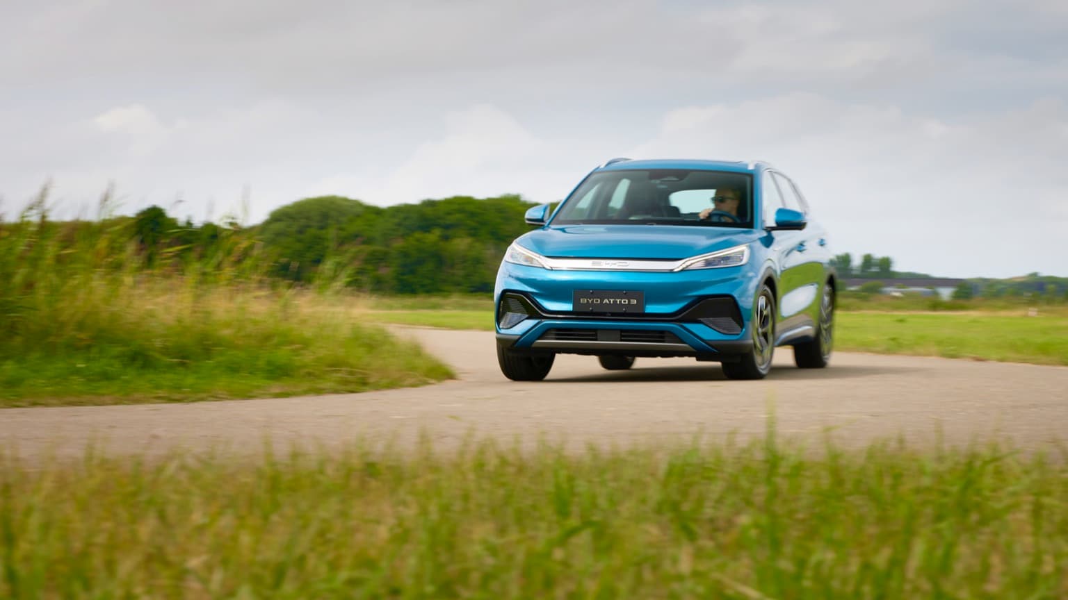 une voiture bleue roulant sur une route