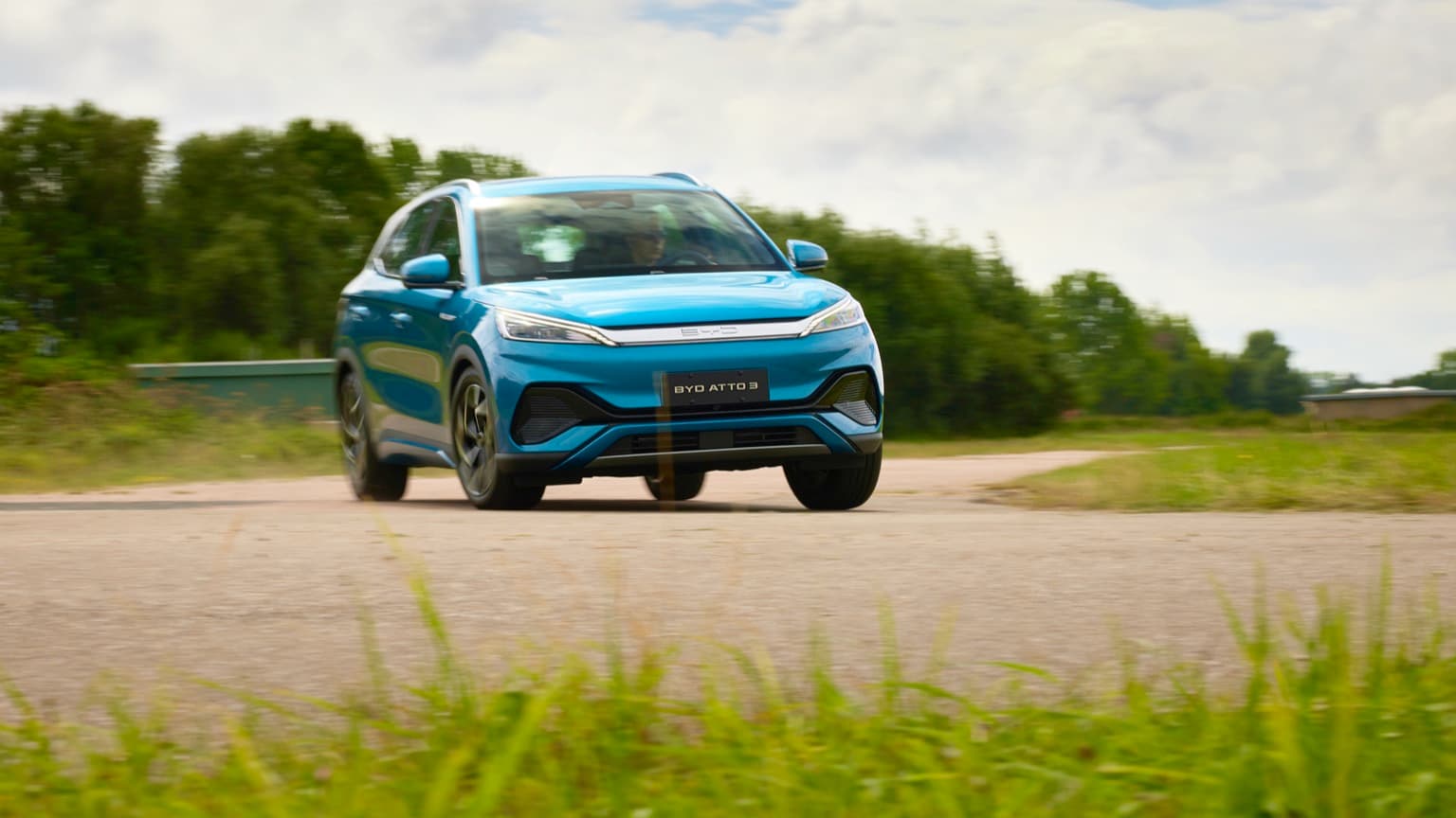 une voiture bleue roulant sur une route