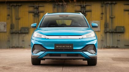 une voiture bleue garée devant un mur jaune