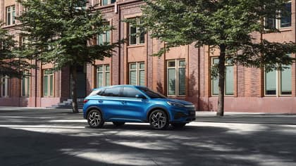 une voiture bleue garée devant un bâtiment en briques