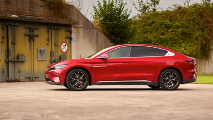 une voiture rouge garée devant une porte jaune