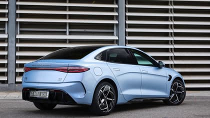 une voiture bleue garée devant un mur métallique