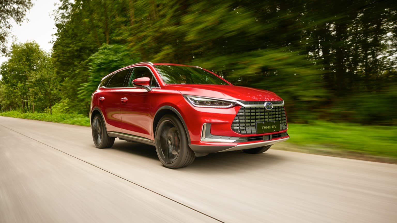 une voiture rouge roulant sur une route