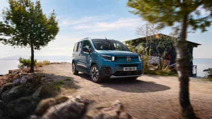 une camionnette bleue roulant sur un chemin de terre