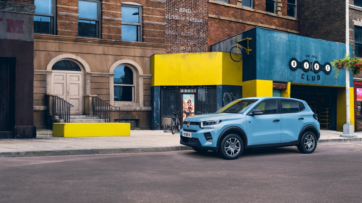 a blue car parked in front of a building
