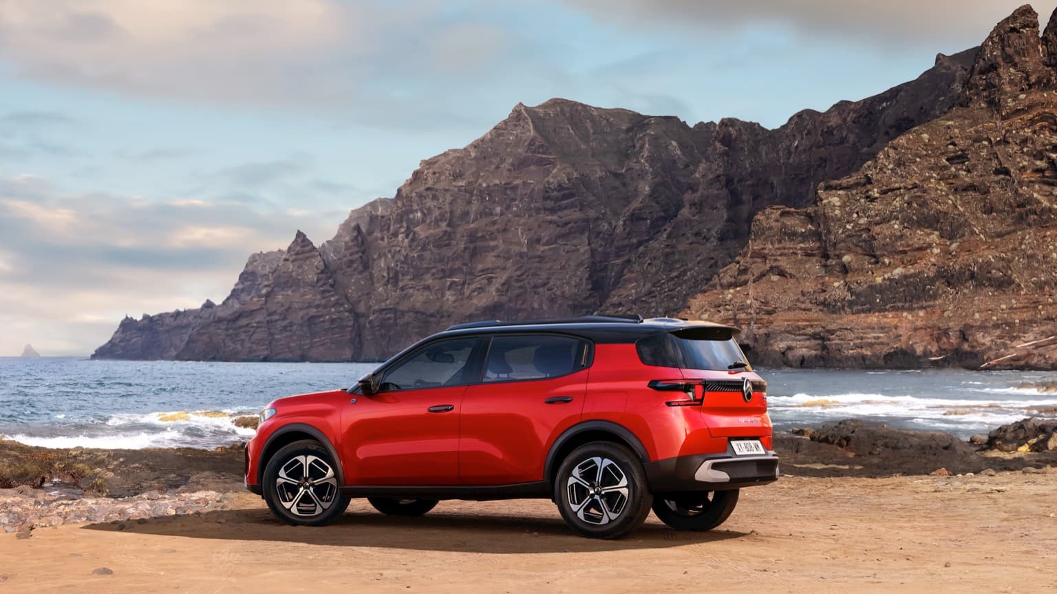 a red car parked on a beach