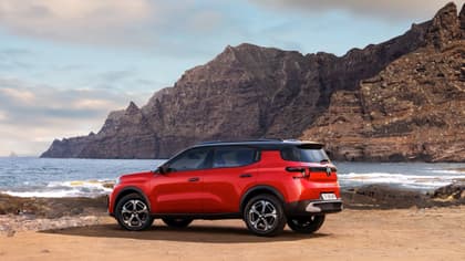 une voiture rouge garée sur une plage