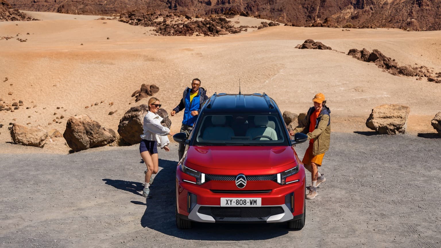 a group of people standing next to a car