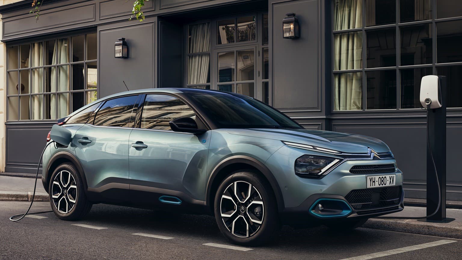 a blue car parked in front of a building