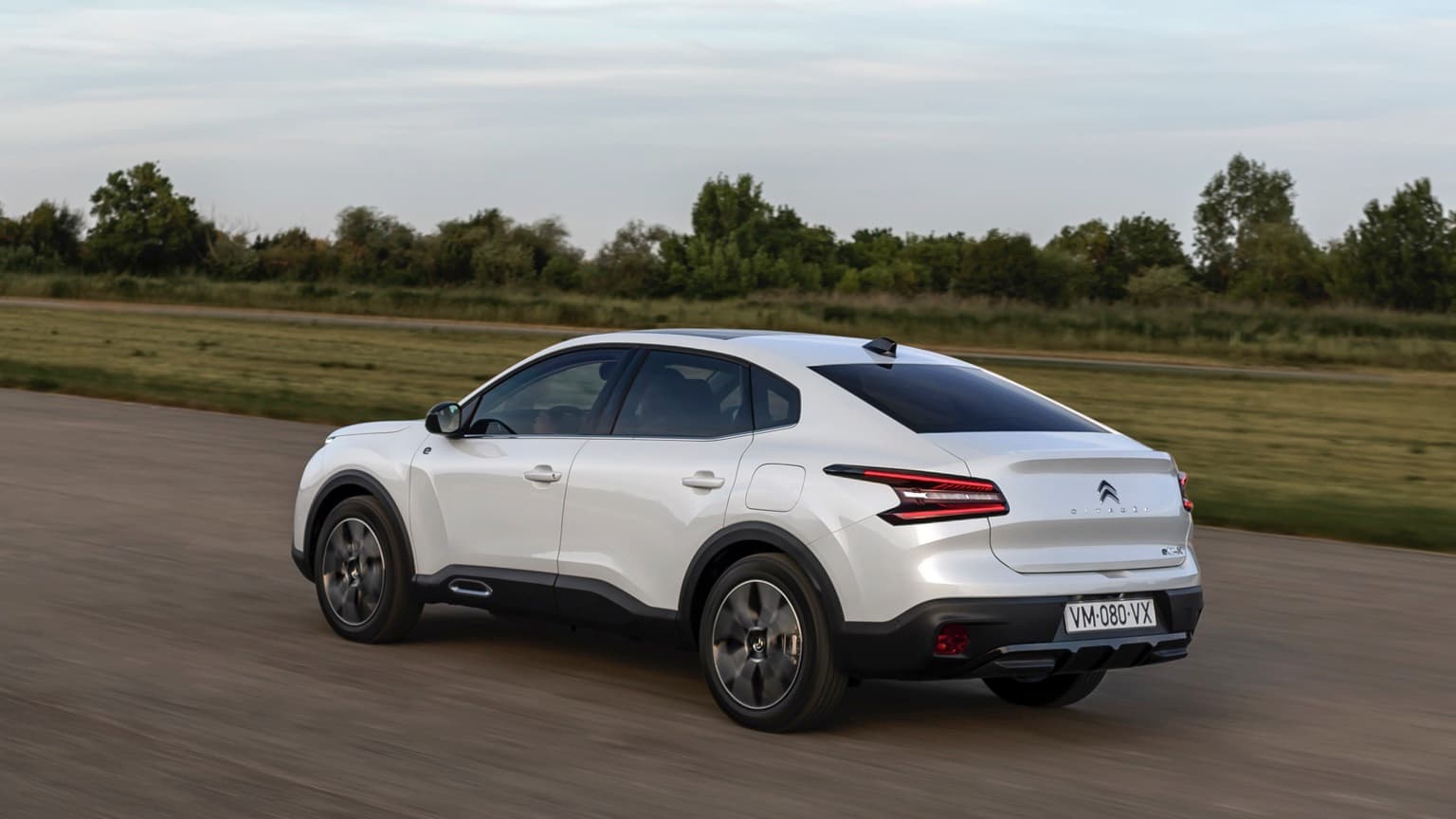 a white car driving on a road