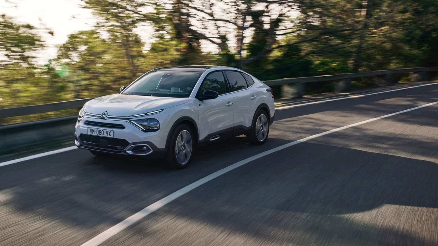 a white car driving on a road