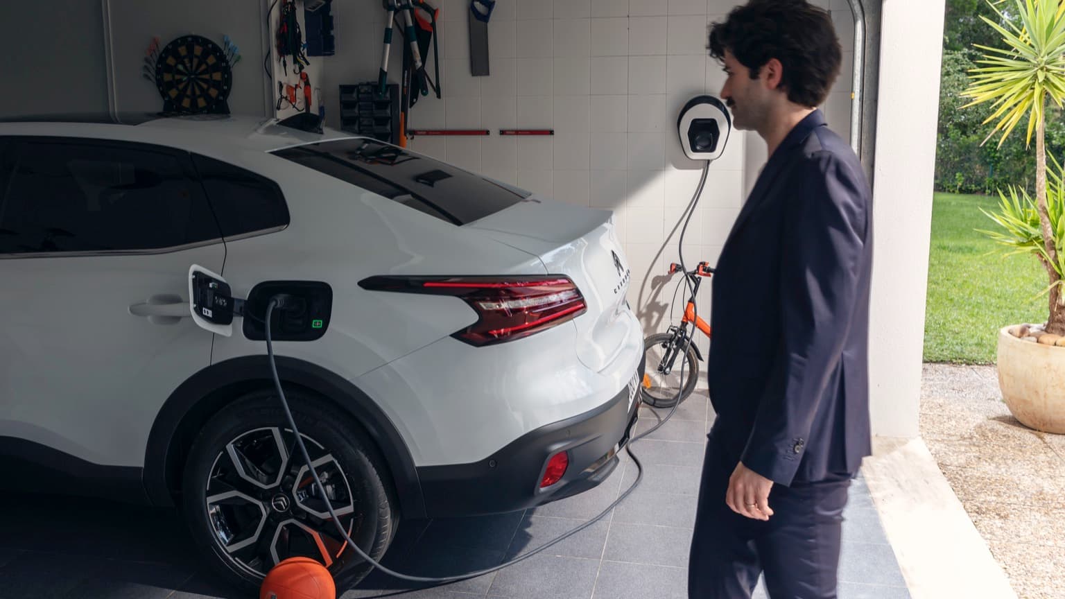 a man in a suit standing next to a car
