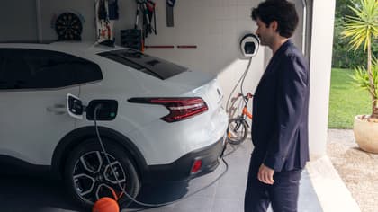 un homme en costume à côté d'une voiture
