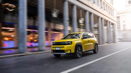 une voiture jaune descendant la rue