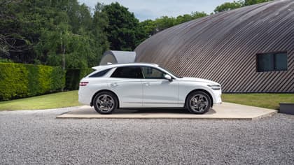 une voiture blanche garée devant un bâtiment incurvé