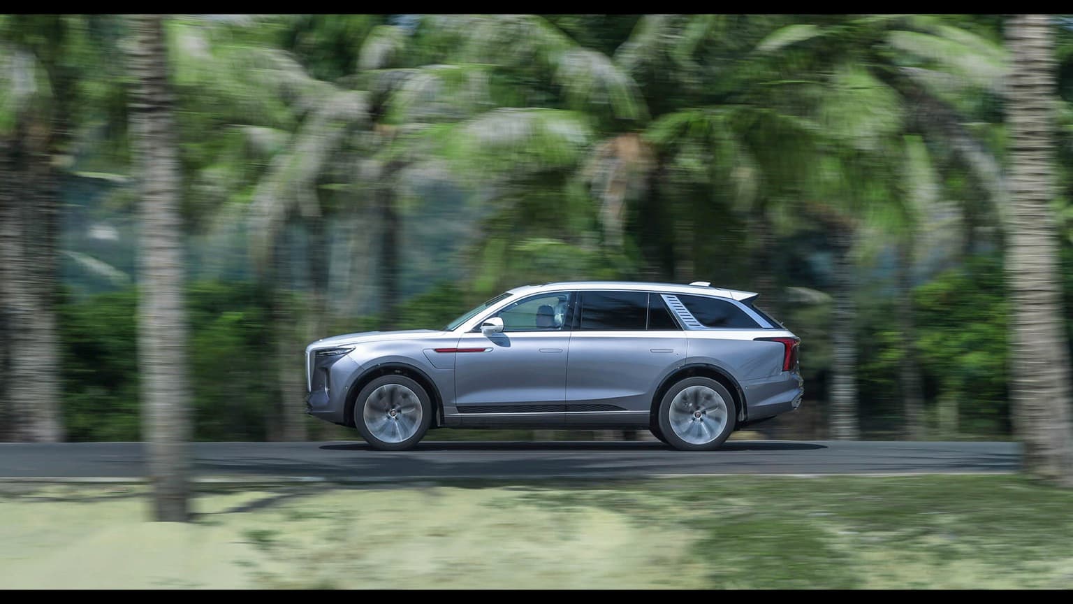 a silver car driving on a road