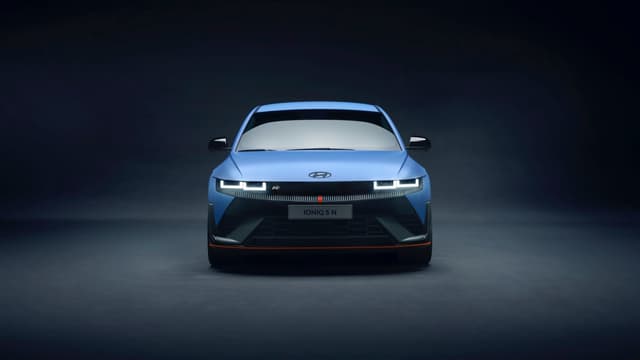 a blue car with its headlights turned on