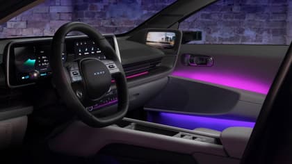 l'intérieur d'une voiture avec un volant et des lumières violettes et roses