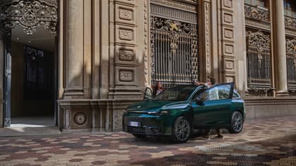 un homme et une femme debout à côté d'une voiture verte