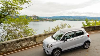 une voiture roulant sur une route au bord d'une étendue d'eau