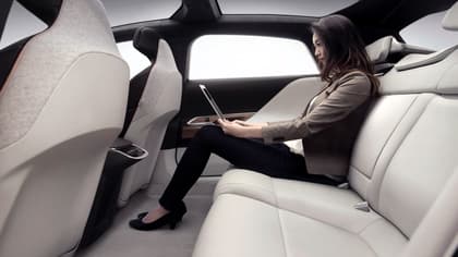 une femme assise dans une voiture avec un ordinateur portable