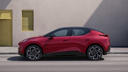 a red and black car parked next to a building