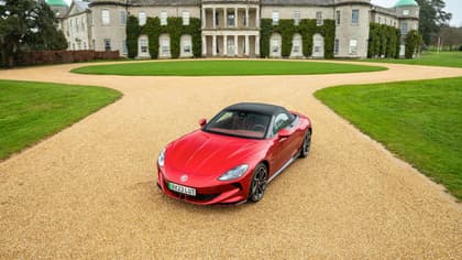 a red sports car parked in front of a large building