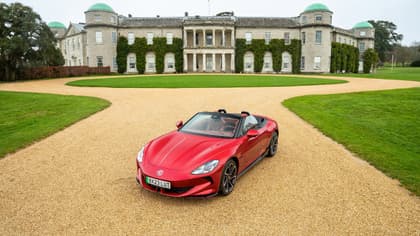 a red sports car parked in front of a large building