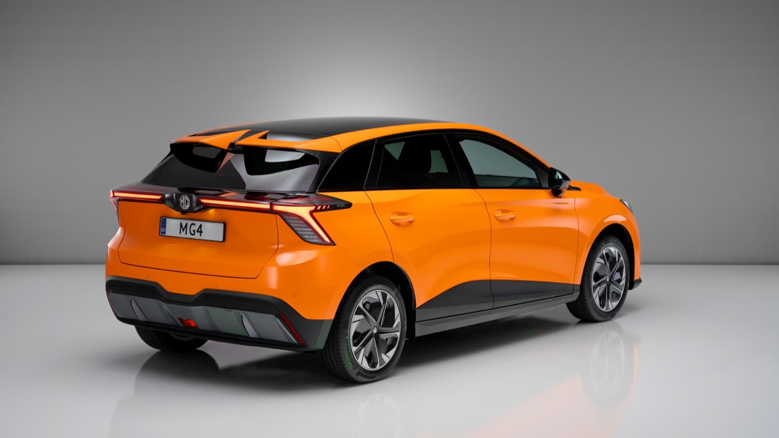 an orange and black car with Holden Arboretum in the background
