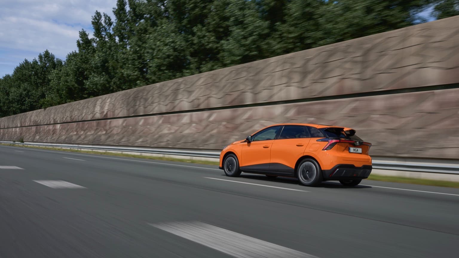 an orange car driving on a road