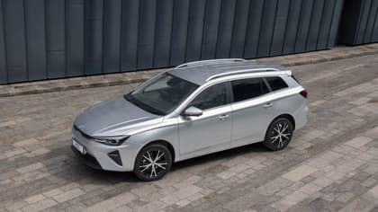a silver car parked on a brick surface